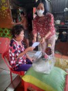 Chị Huỳnh Thị Trường, Chi hội phó Chi hội Phụ nữ ấp Long Khương, xã Long Thành Nam trao quà cho phụ nữ nghèo ở ấp Long Khương
